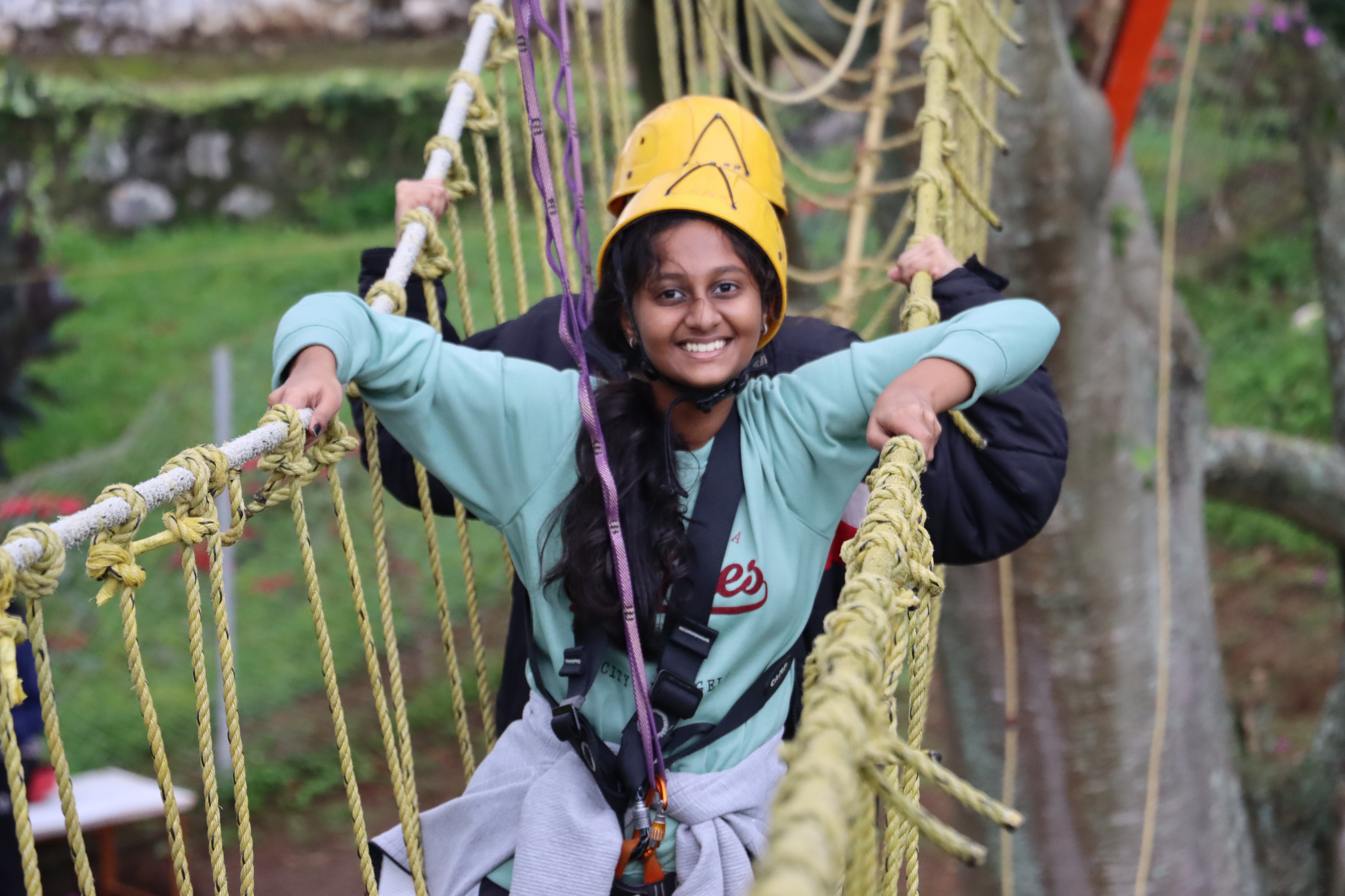 AWS student smiling on a rope-net climbing course