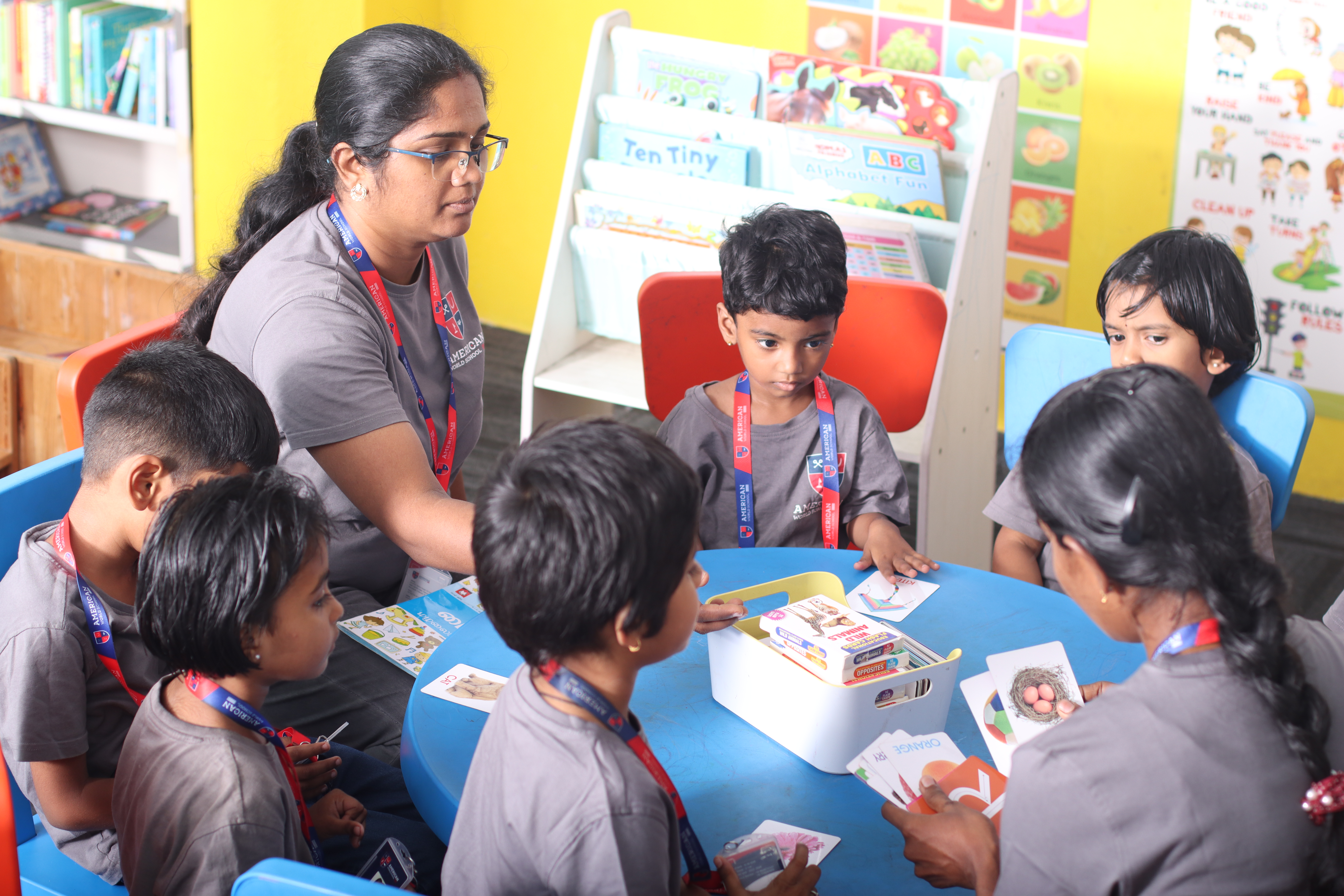 AWS teacher with young students at a table with picture cards