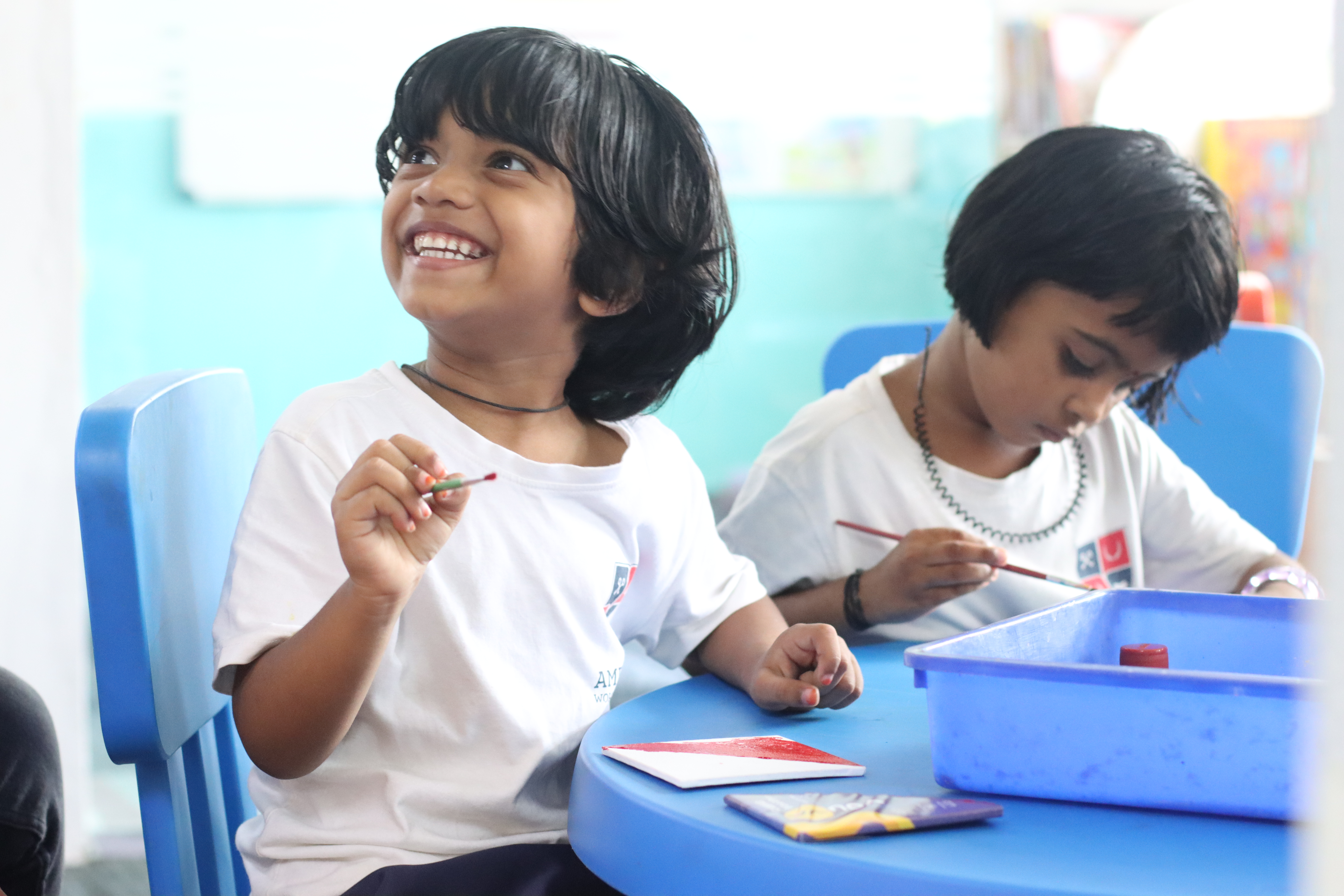 Young AWS students painting and laughing