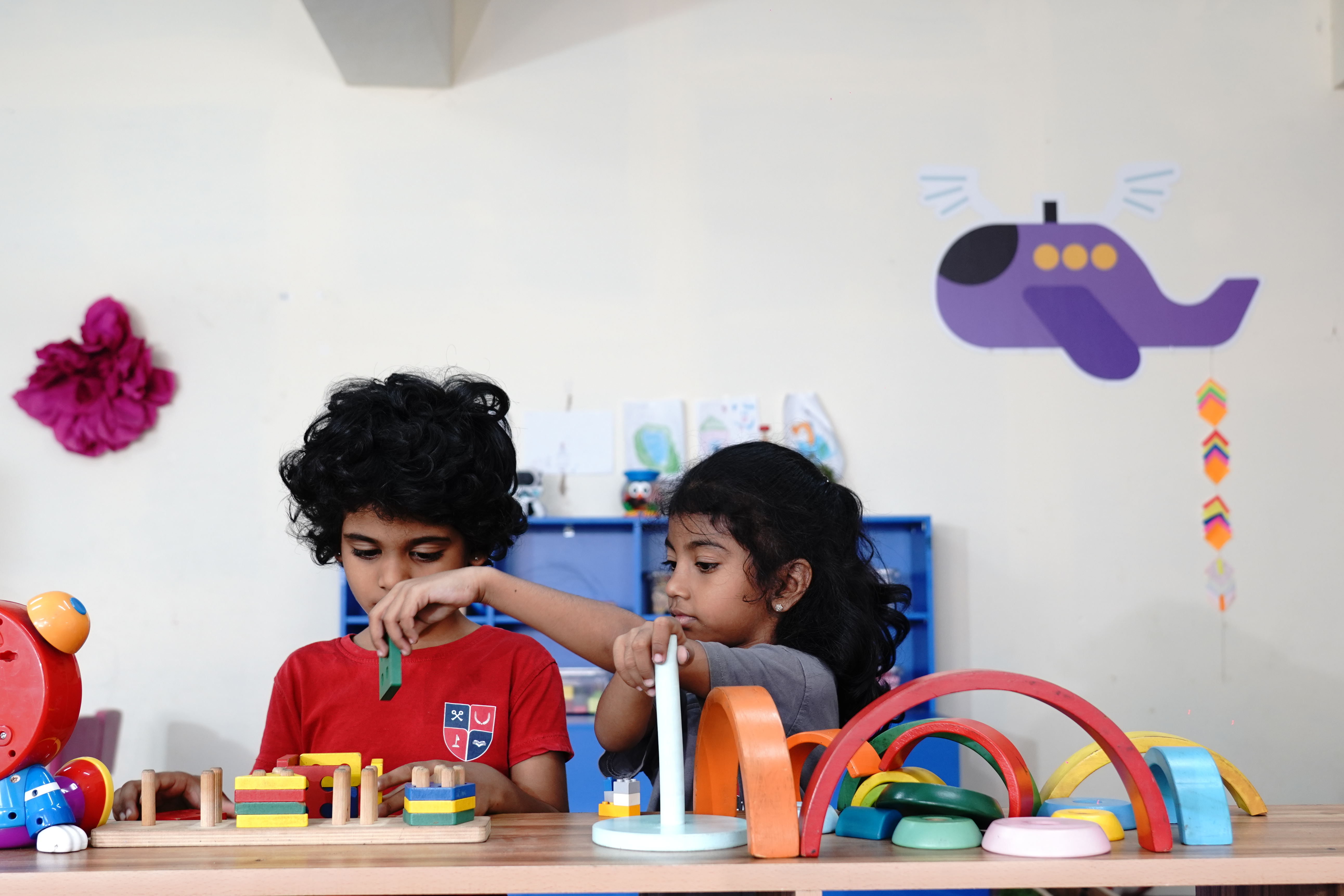 Young children playing with wooden Montessori-style blocks