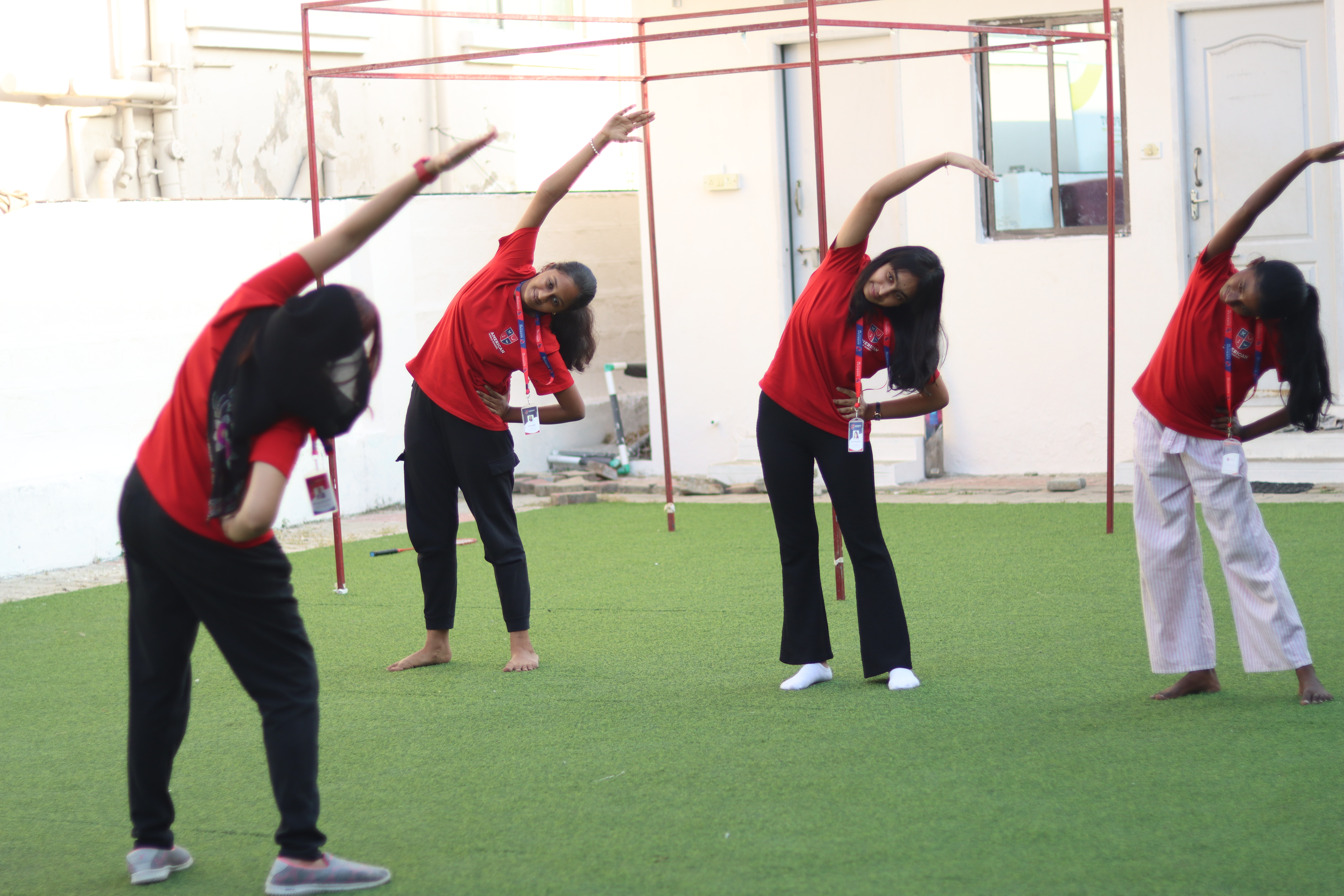 AWS girls including a hijabi student doing yoga together