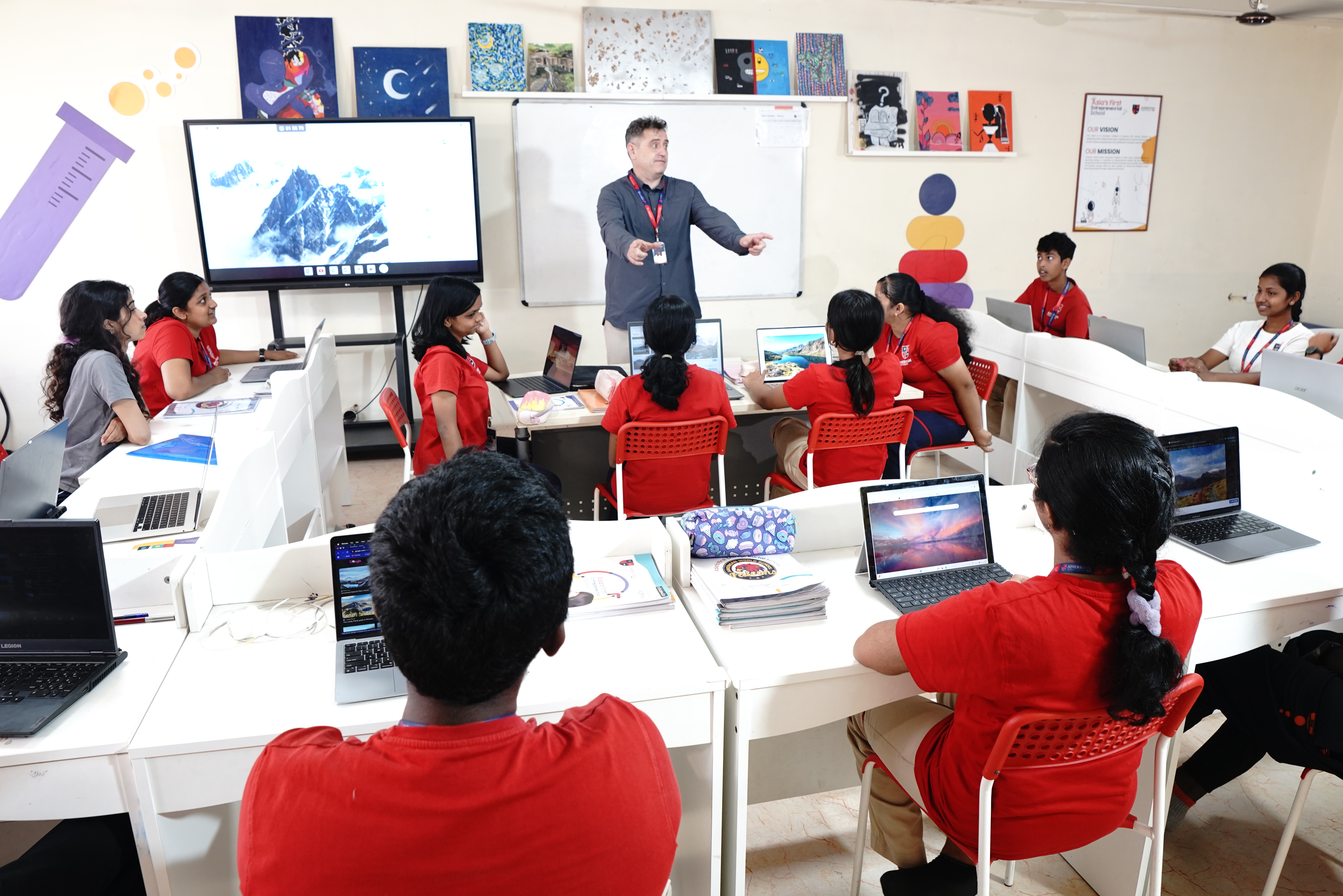 AWS teacher pointing to a mountain image on a smart screen during a lesson