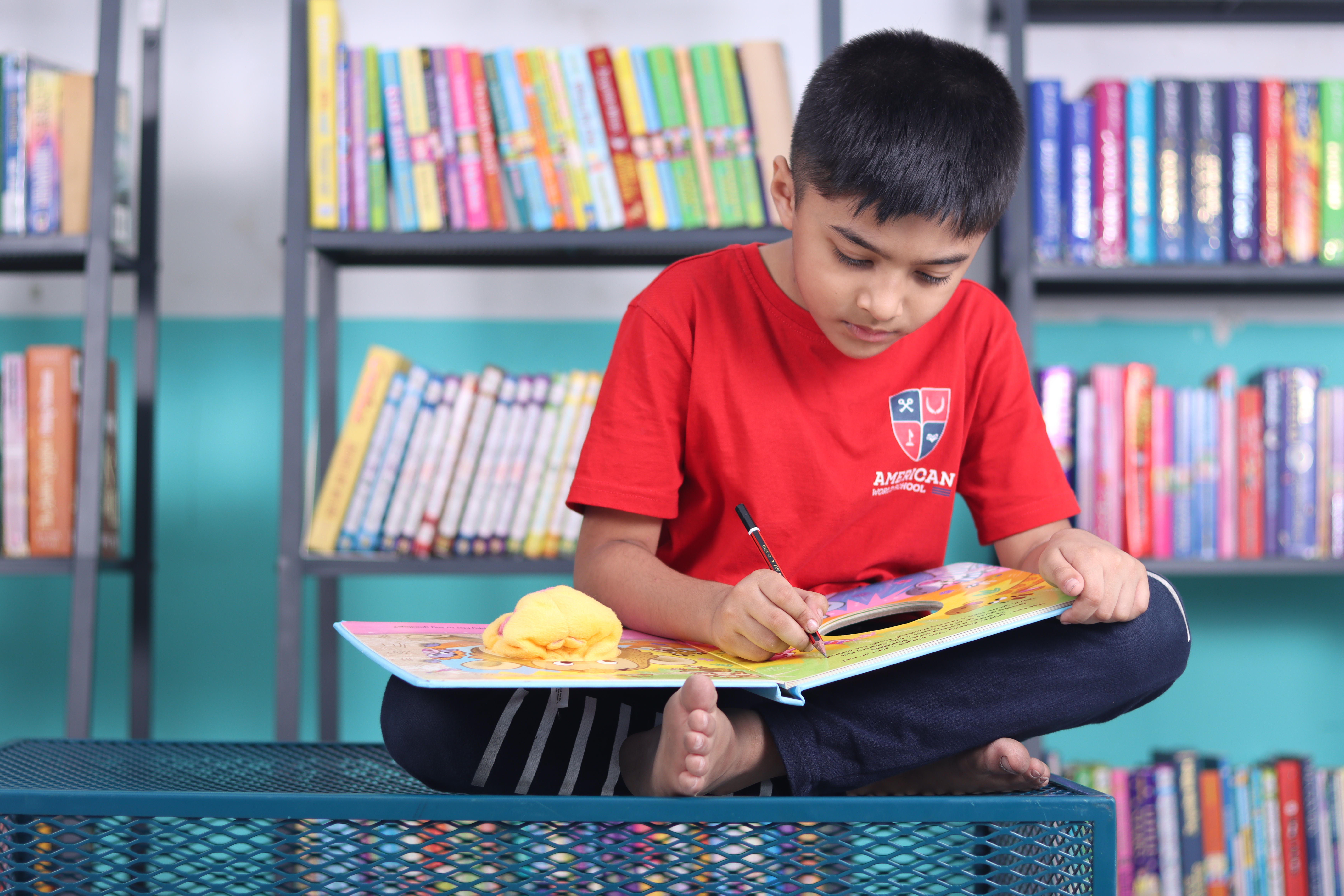 AWS lower elementary student painting on a library bench