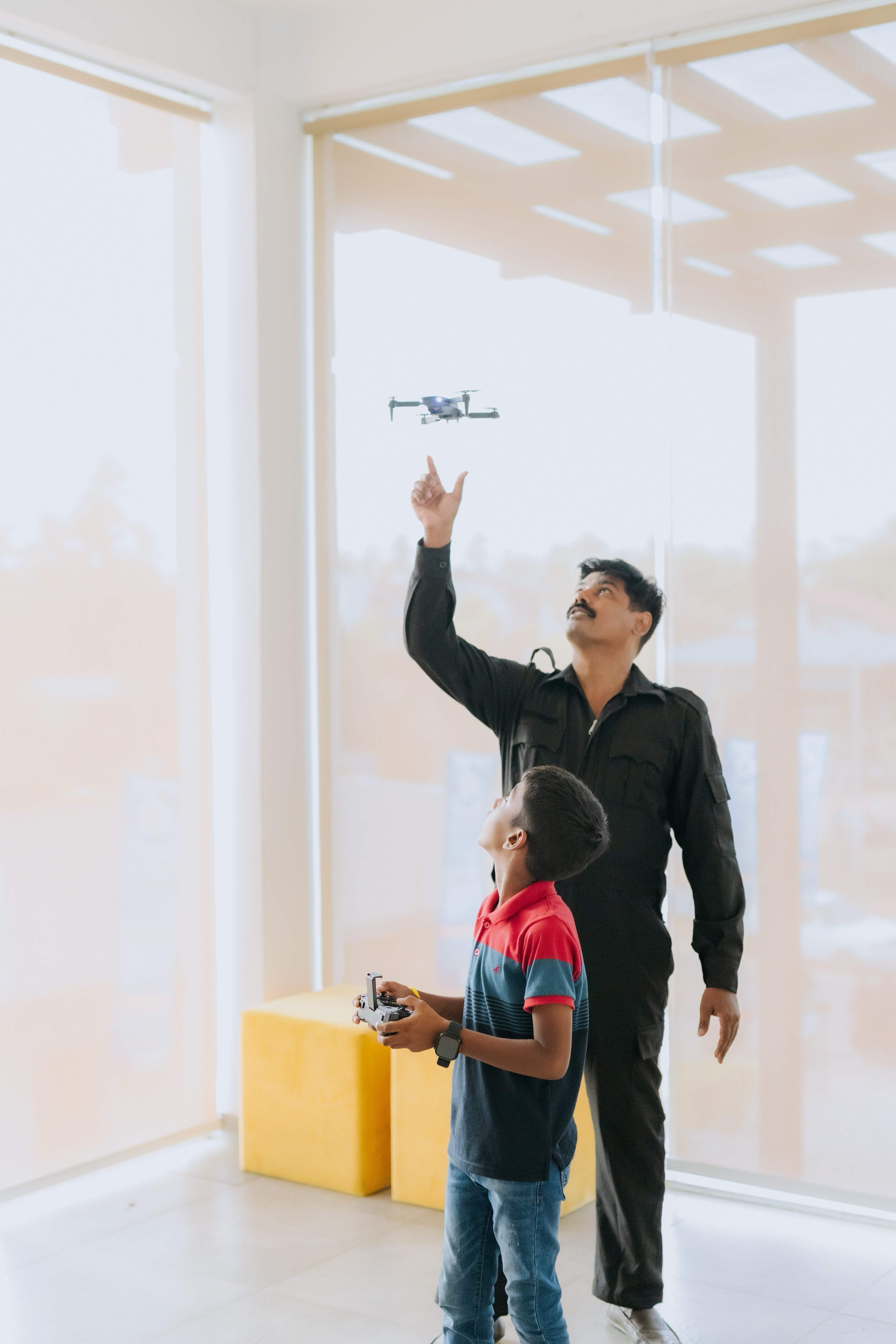 Young AWS student flying a small drone with an instructor