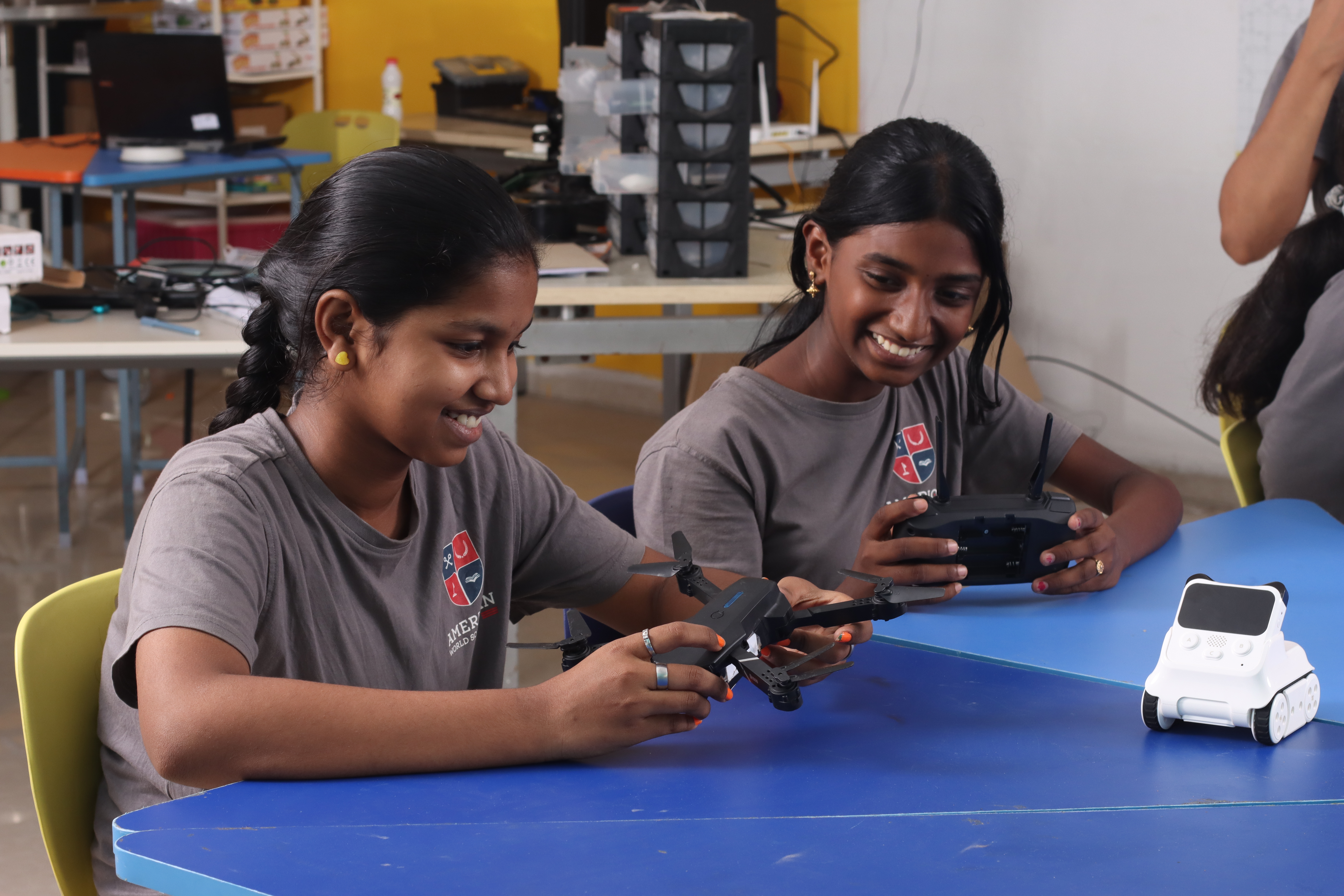 AWS middle school students with a drone and a robot in the Maker Lab