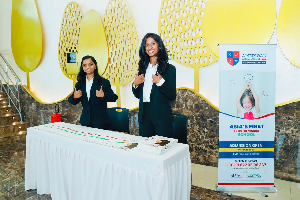 AWS students at the admission desk with Asia’s First Entrepreneurial School banner