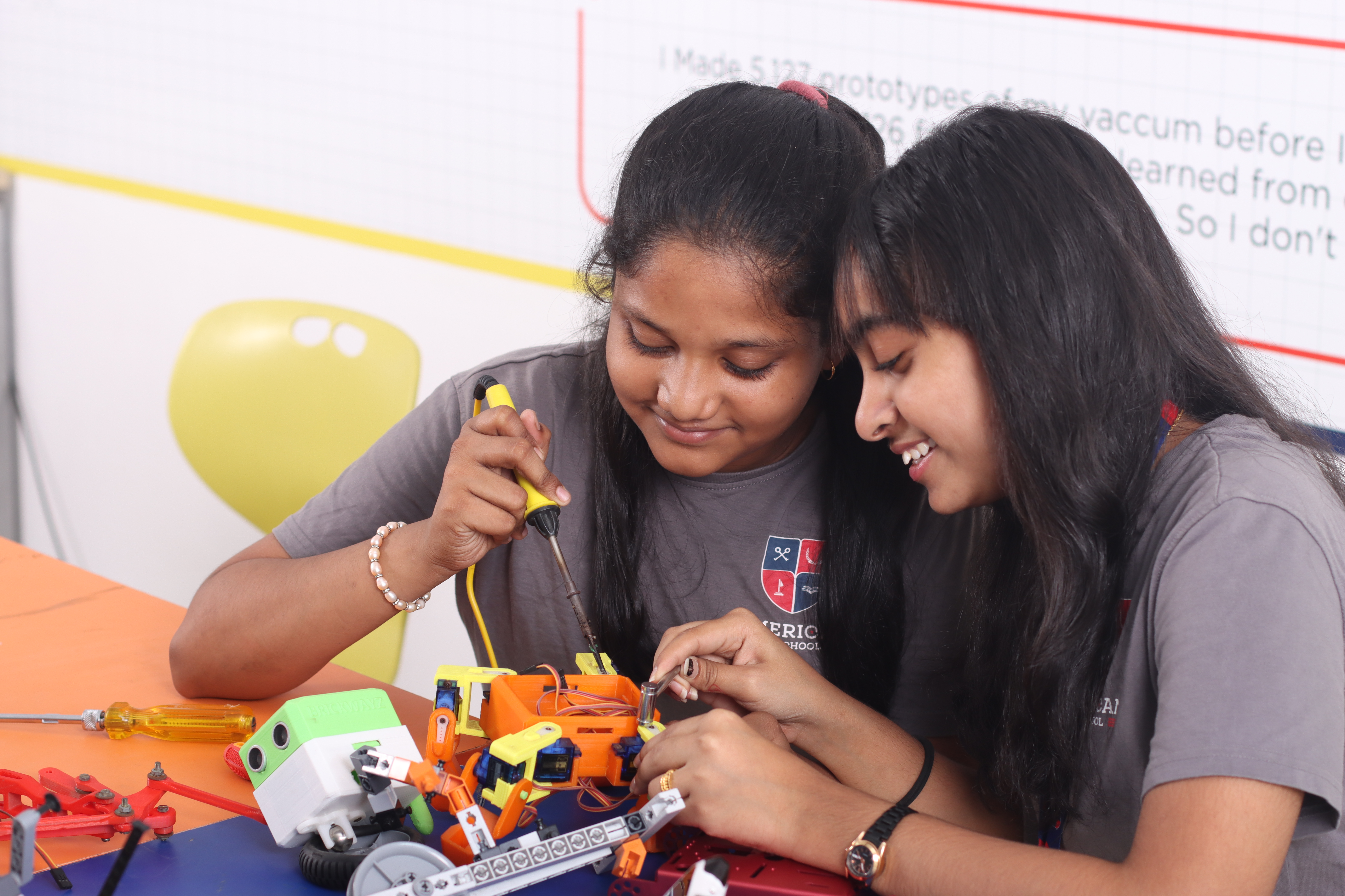 AWS students using a screwdriver on a robotics project