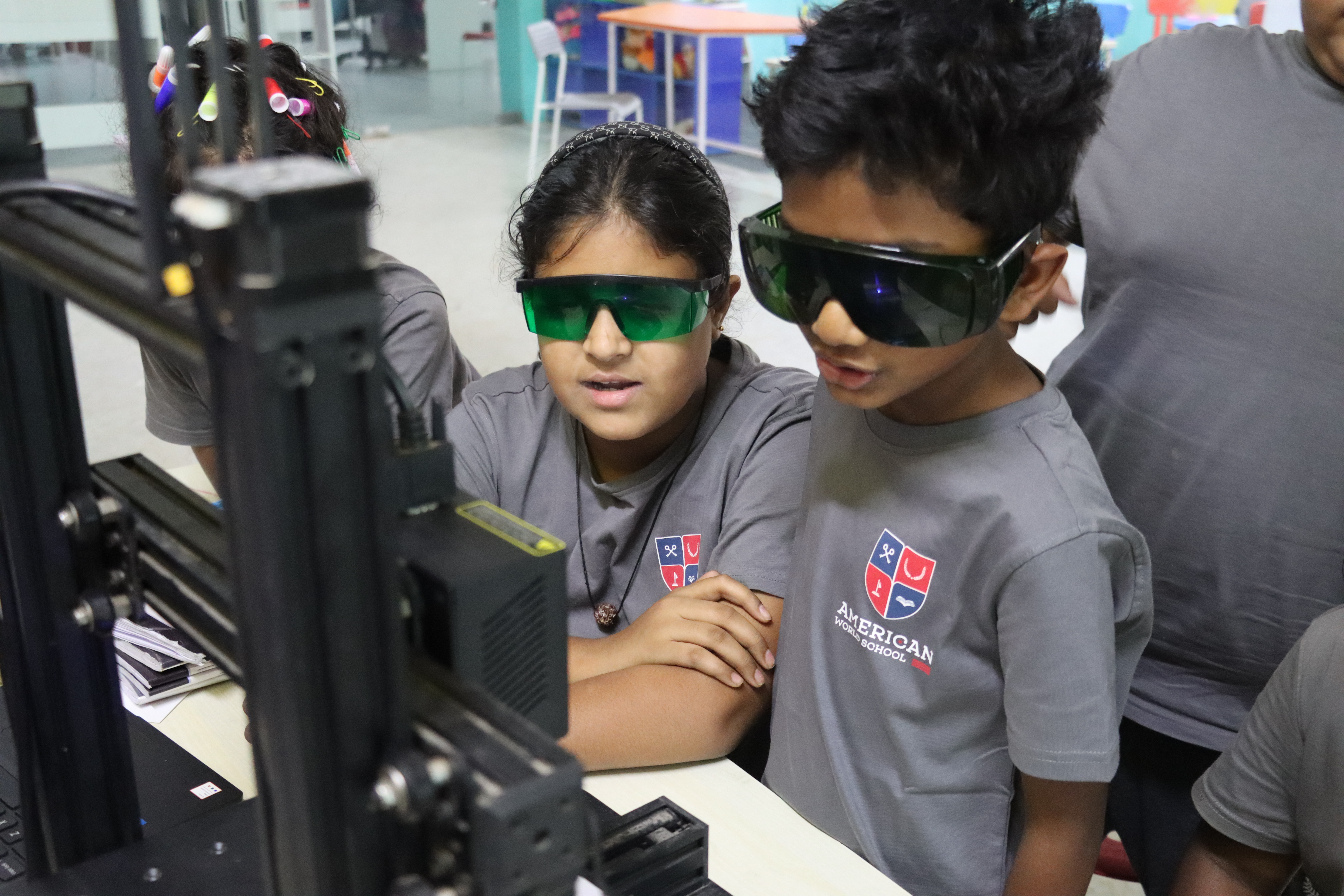Upper Elementary students using 3D printing tools at AWS