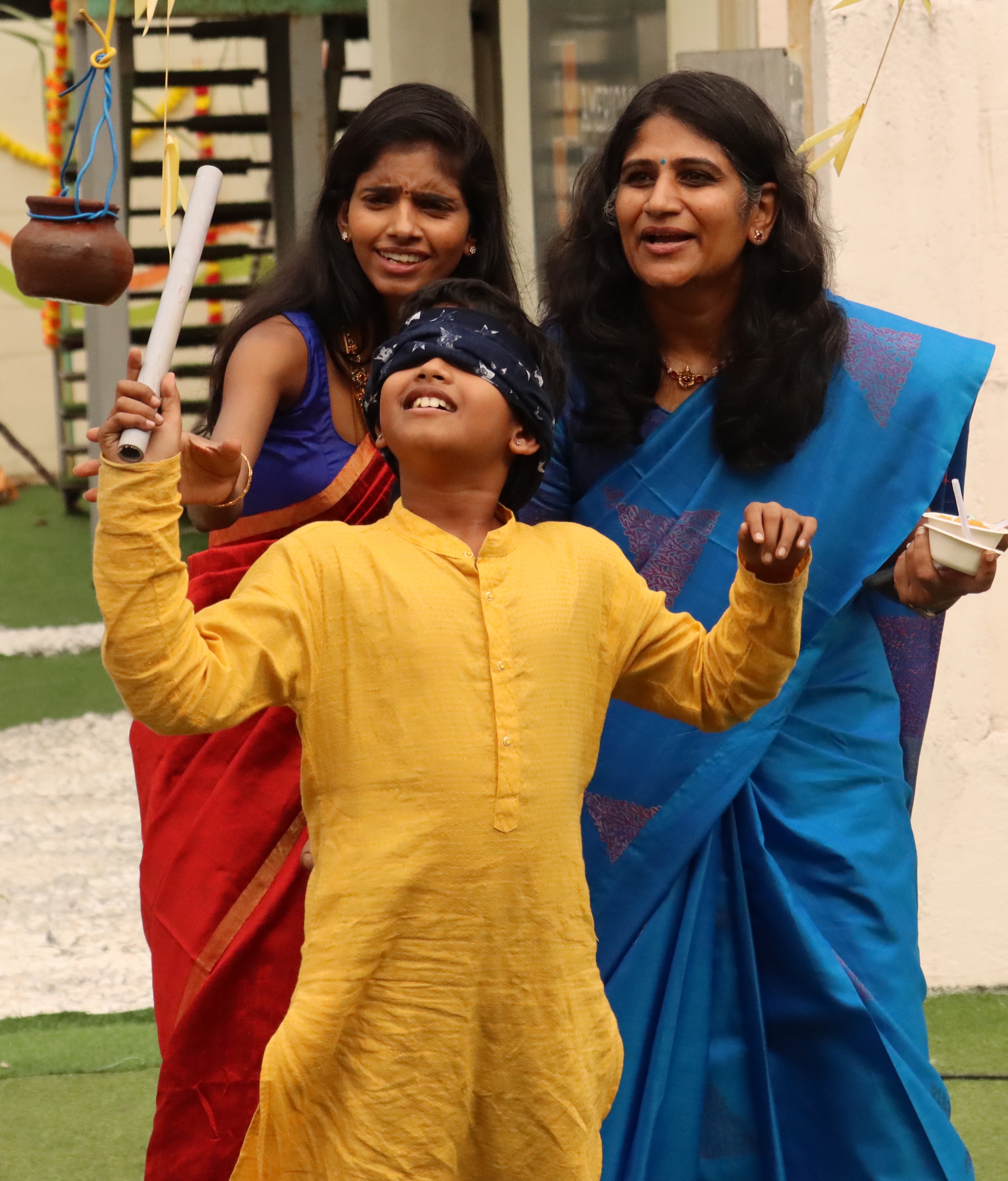 AWS upper elementary student playing the Uri Adi pot-breaking game during Pongal