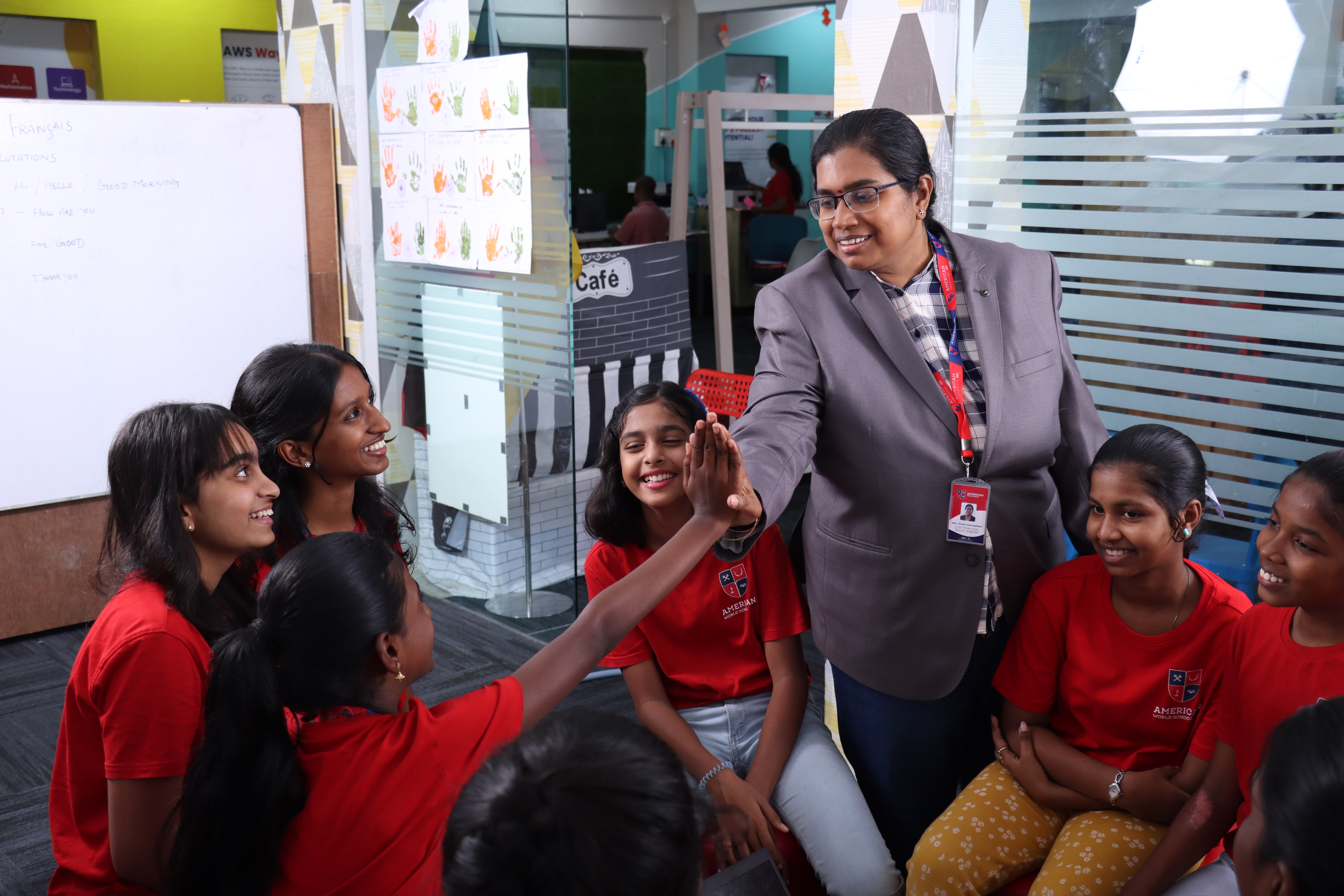 AWS teacher high-fiving happy students in classroom