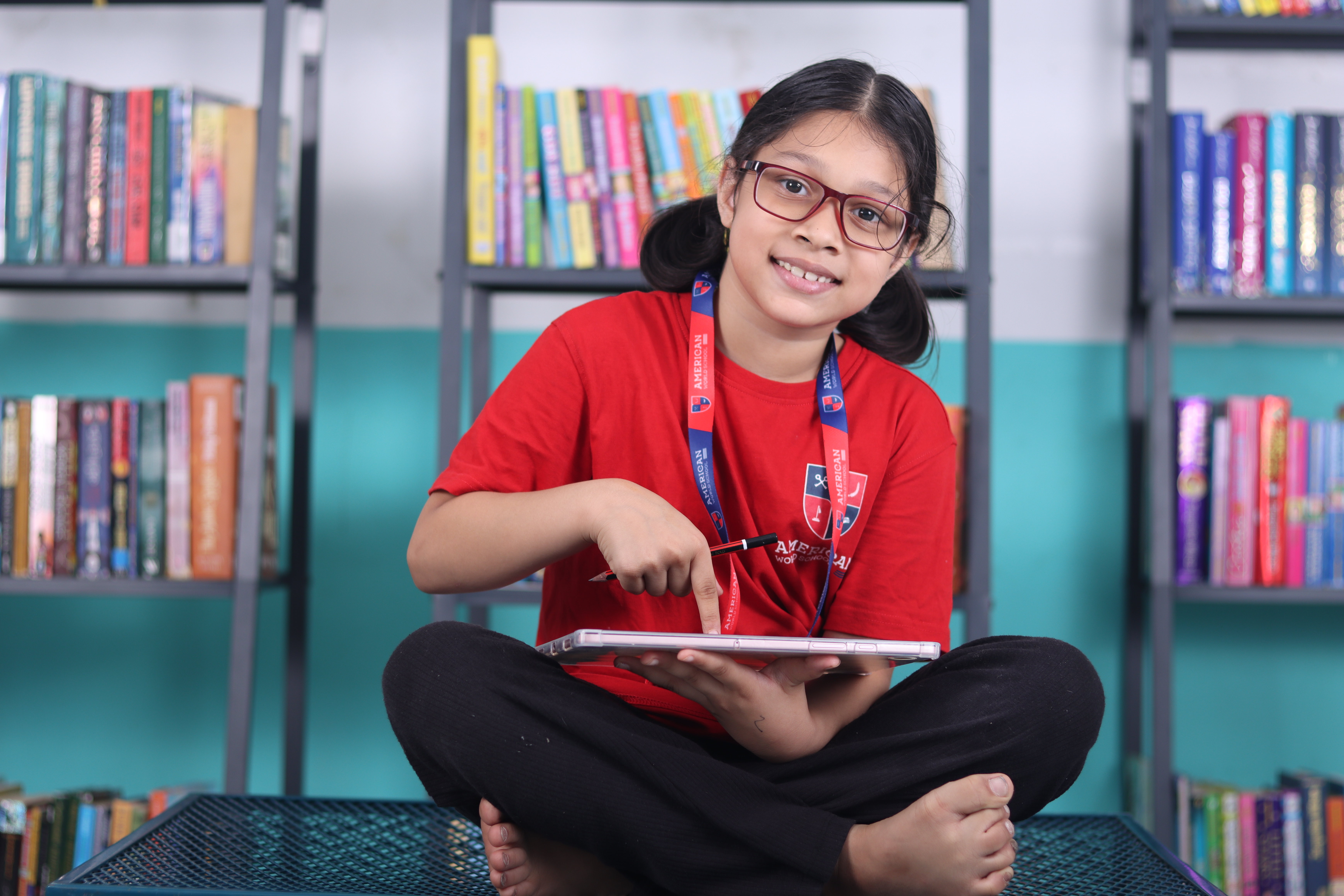 Happy AWS student in the library holding her book